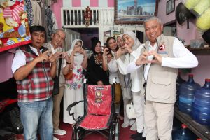 Ny. Uun tengah busana hitam, bersama rombongan Yastroki di serambi rumahnya. (foto ist)